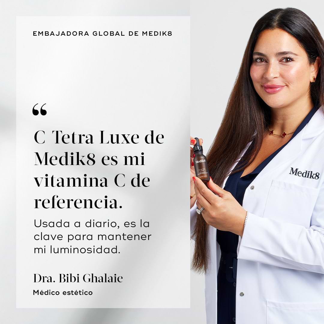Dr. Bibi Ghalaie sonríe mientras lleva una bata de laboratorio blanca de Medik8 y sostiene una botella marrón de C-Tetra Luxe. A su lado aparece una cita que dice: «C-Tetra Luxe de Medik8 es mi vitamina C de referencia. Utilizada a diario, es la clave para mantener mi luminosidad».
