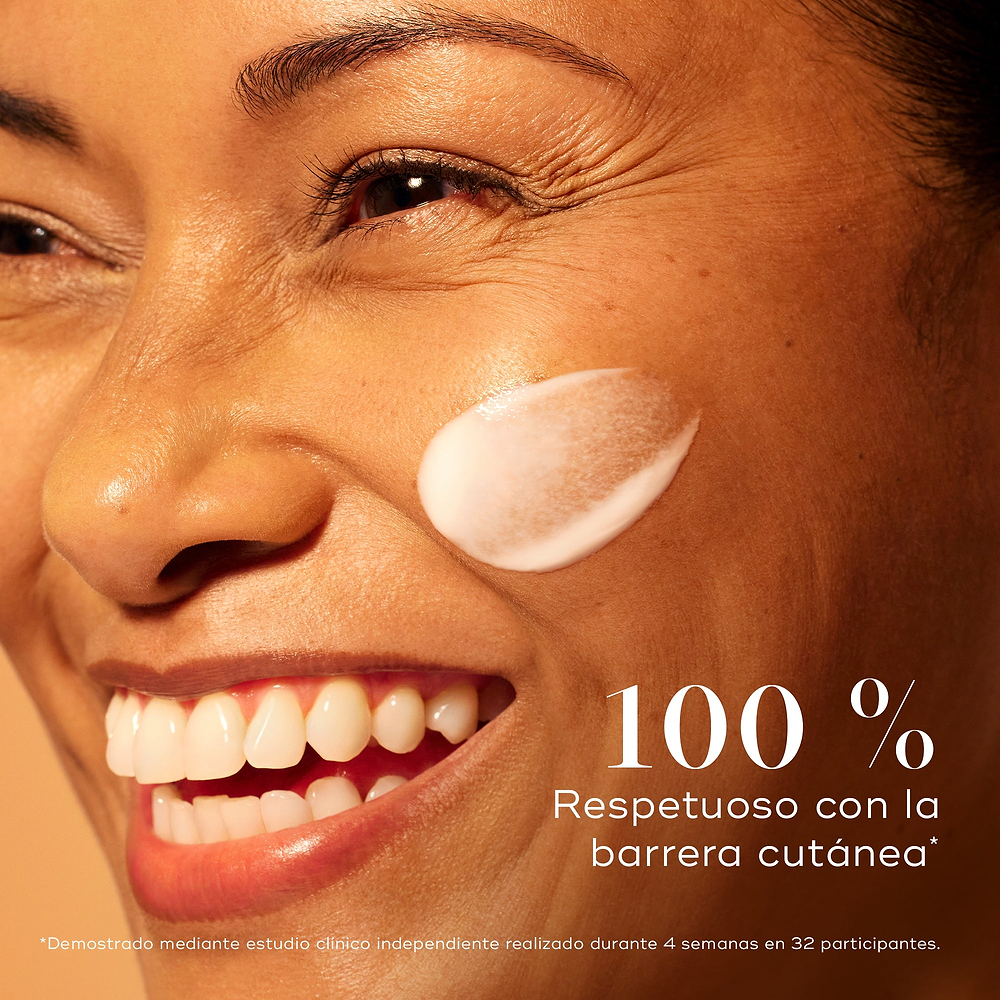Mujer sonriente con una piel radiante y una aplicación de sérum Medik8 C-Tetra Advanced en la mejilla, destacando un 0 % de alteración de la barrera cutánea para una luminosidad suave pero eficaz.