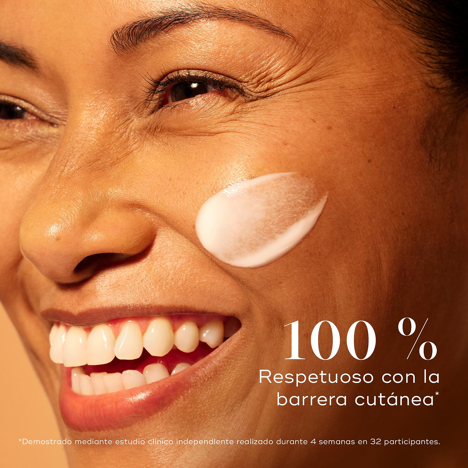 Mujer sonriente con una piel radiante y una aplicación de sérum Medik8 C-Tetra Advanced en la mejilla, destacando un 0 % de alteración de la barrera cutánea para una luminosidad suave pero eficaz.
