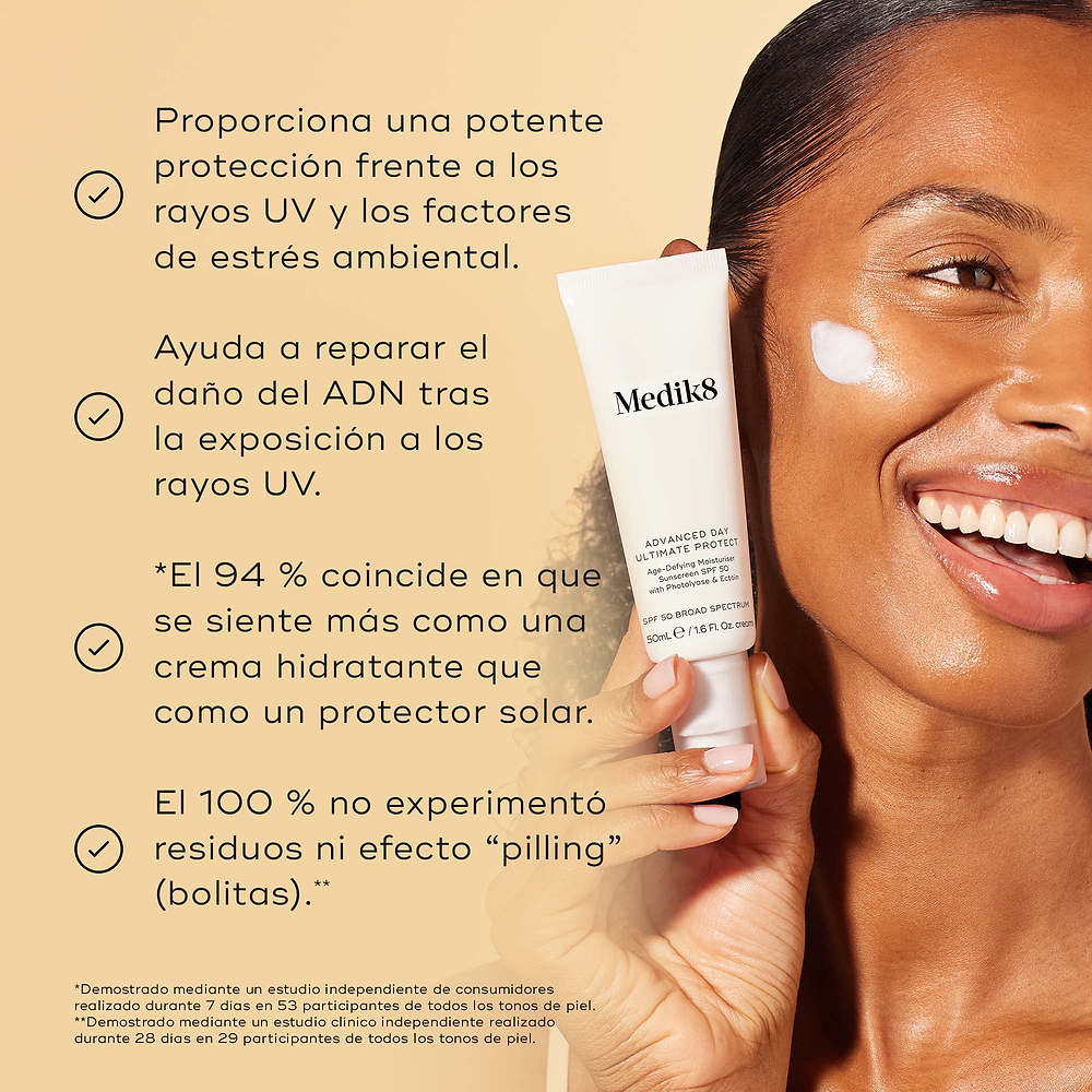 Un modelo sonriente sostiene el tubo de Medik8 Advanced Day Ultimate Protect con una muestra de crema blanca en la mejilla sobre un fondo beige cálido. El texto destaca cuatro beneficios clave: protección avanzada contra los rayos UV y los factores de estrés ambiental, reparación del daño en el ADN tras la exposición a los rayos UV, el 94 % está de acuerdo en que se siente como una crema hidratante y el 100 % no experimentó formación de grumos ni efecto “pilling”.
