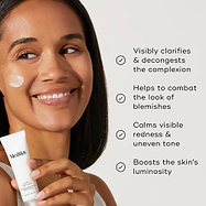 A woman holding Clarity Peptides, with a small amount of product on their cheek. Four bullet points with checkmarks list benefits: Visibly clarifies & decongests the complexion, Helps to combat the look of blemishes, Calms visible redness & uneven tone, and Boosts the skin's luminosity.