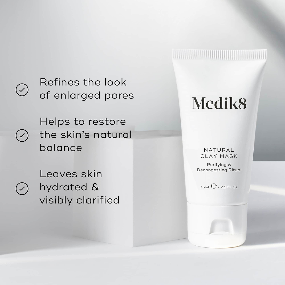 Natural Clay Mask is featured on a white geometric block. Three bullet points with checkmarks list benefits: Refines the look of enlarged pores, Helps to restore the skin's natural balance, and Leaves skin hydrated & visibly clarified.