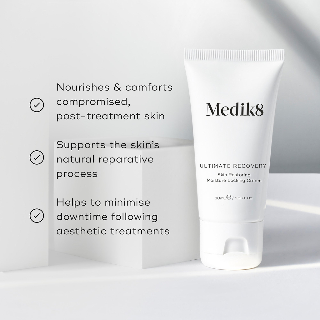 A white tube of Ultimate Recovery Skin Restoring Moisture Locking Cream is featured on a white geometric block. Three bullet points with checkmarks list benefits: Nourishes & comforts compromised, post-treatment skin, Supports the skin's natural reparative process, and Helps to minimise downtime following aesthetic treatments.