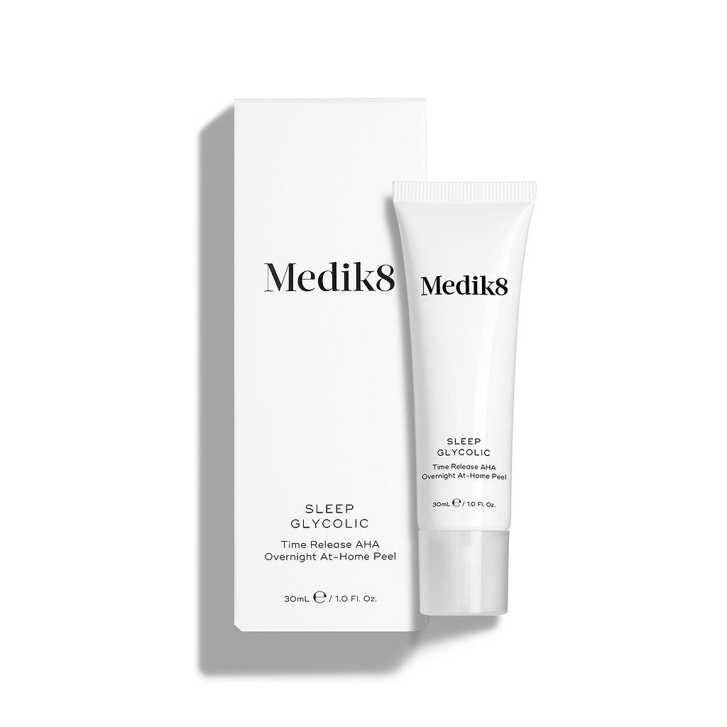Medik8 Sleep Glycolic tube stands in front of its matching white product carton on a clean white background. Text on both the tube and box identifies the product as a 30mL "Time Release AHA Overnight At-Home Peel."