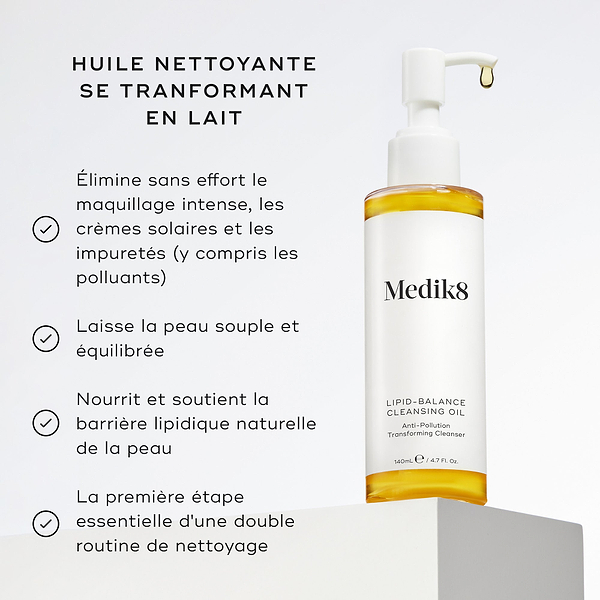 Le flacon de Medik8 Lipid-Balance Cleansing Oil est posé sur un bloc blanc. Le texte énumère les bénéfices, notamment le démaquillage intense, le soutien de la barrière lipidique et son action de nettoyant transformant l’huile en lait.
