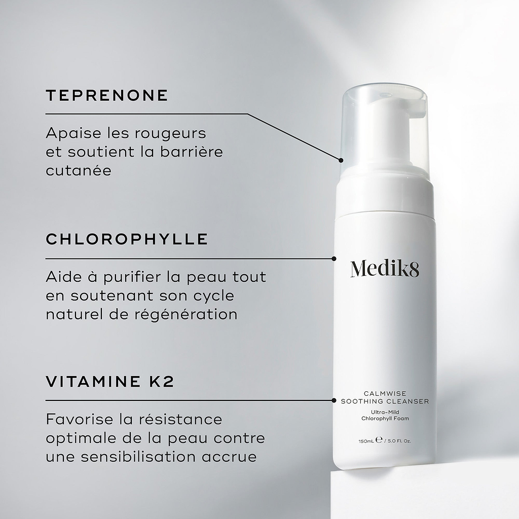 Un flacon de Medik8 Calmwise Soothing Cleanser présenté sur un bloc blanc. Des lignes relient le flacon à un texte expliquant les principaux ingrédients : le téprénone pour apaiser les rougeurs, la chlorophylle pour purifier la peau et la vitamine K2 pour soutenir la solidité de la peau.c