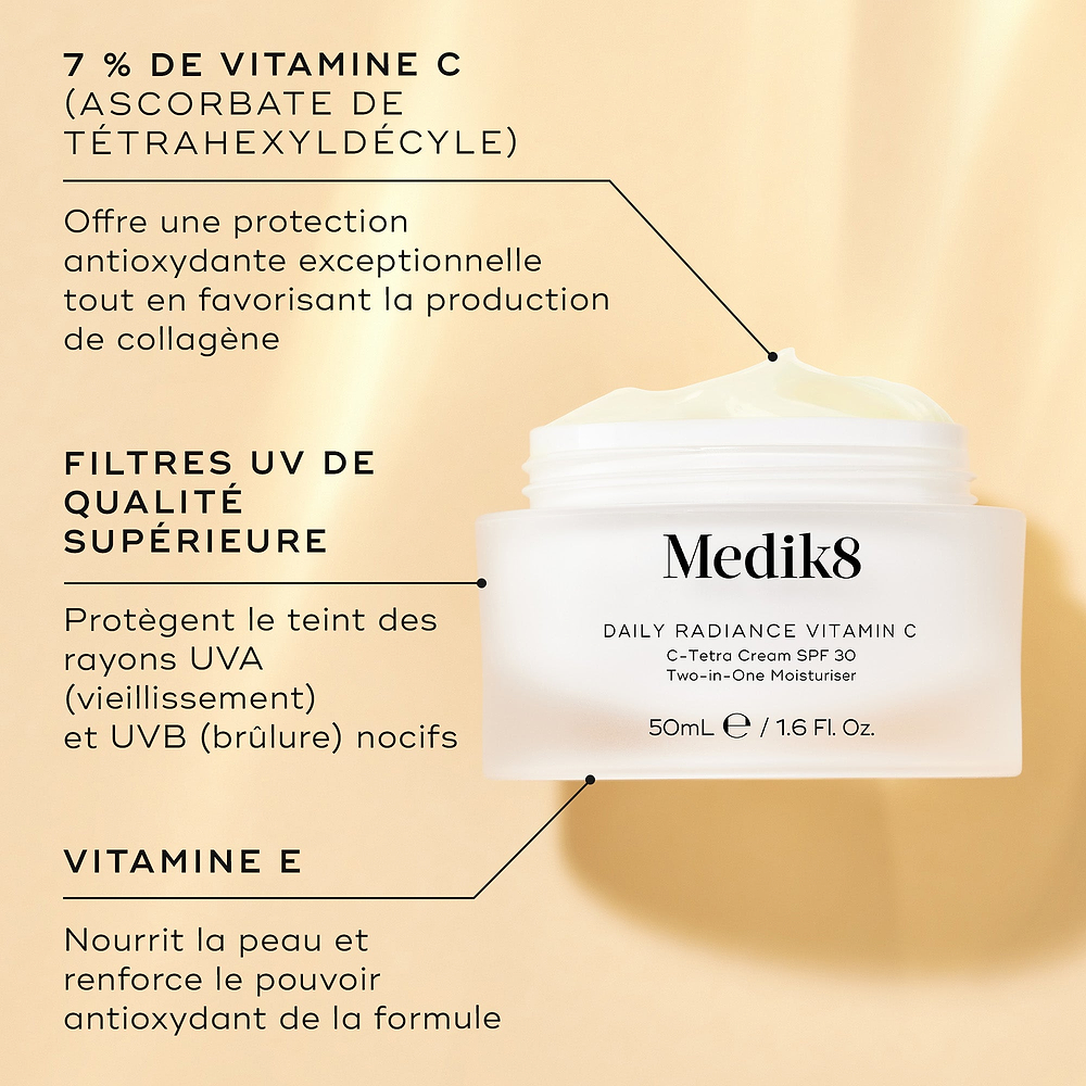 Pot en verre ouvert de Medik8 Daily Radiance Vitamin C présenté sur un fond doré chaud avec des indications d’ingrédients. Le texte met en avant 7 % de vitamine C (Tetrahexyldécyl ascorbate) pour une protection antioxydante et un soutien du collagène, des filtres UV premium pour une protection UVA et UVB, ainsi que la vitamine E pour nourrir la peau et renforcer le pouvoir antioxydant.