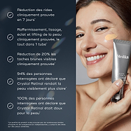 Une femme à la peau éclatante et nette sourit vivement tout en appliquant délicatement une petite quantité de Medik8 Crystal Retinal d'un tube argenté sur sa joue. Le produit a une teinte jaune pâle. Des points à puces en allemand sur la gauche décrivent les bienfaits du produit.