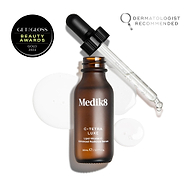 Flacon de sérum Medik8 C-Tetra Luxe ouvert avec sa pipette en verre reposant sur le rebord, présenté sur un fond blanc avec des gouttelettes de sérum translucides. L'image inclut un sceau GET THE GLOSS BEAUTY AWARDS GOLD 2024 en haut à gauche et un emblème DERMATOLOGIST RECOMMENDED avec icône loupe en haut à droite