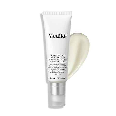 Tuba Medik8 Advanced Day Total Protect stojí na čistém bílém pozadí s velkým tahem krémově bílého hydratačního krému.