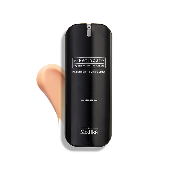 Medik8 r-Retinoate Intense Youth Activating Cream-Flasche auf weißem Hintergrund mit einem Swatch der pfirsichfarbenen Creme im Hintergrund-9