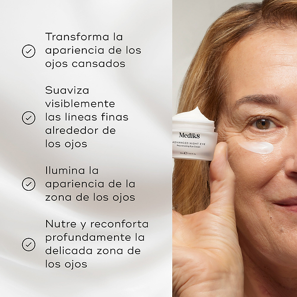 Una mujer rubia sostiene un tarro abierto esmerilado de Medik8 Advanced Night Eye cerca de su rostro, que tiene una pequeña aplicación de crema blanca debajo del ojo. La etiqueta lo identifica como una “Crema Rejuvenecedora para el Contorno de Ojos”, sobre un fondo blanco limpio.-hover-4
