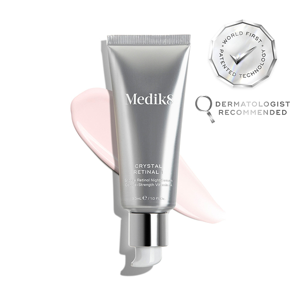 A silver tube of Crystal Retinal 1 is displayed, with a pink cream swatch to its right. A WORLD FIRST PATENTED TECHNOLOGY seal and a DERMATOLOGIST RECOMMENDED icon are shown. -1