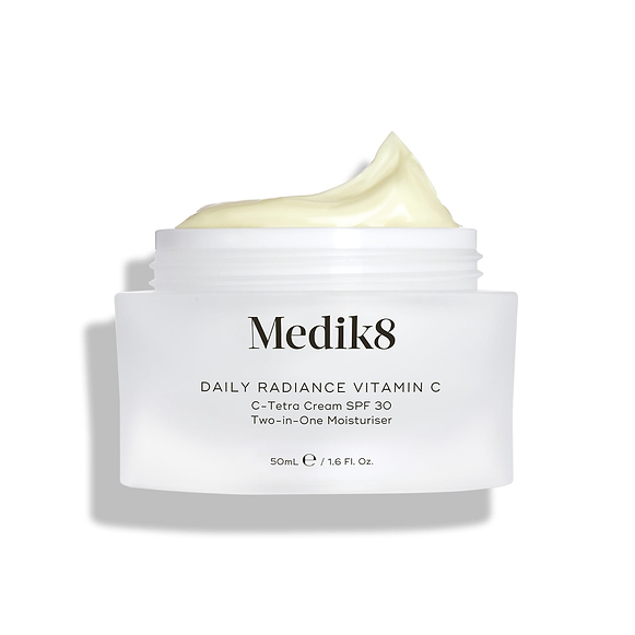 Pot de verre Medik8 Daily Radiance Vitamin C ouvert avec un généreux pic de crème jaune pâle sur le dessus. Le texte identifie le produit comme un C-Tetra Cream SPF 30 Two-in-One Moisturiser de 50 mL