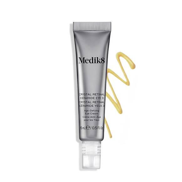 Tubo di crema Medik8 Crystal Retinal Ceramide Eye 3 accanto a una striscia a zigzag di crema gialla su uno sfondo bianco.-2