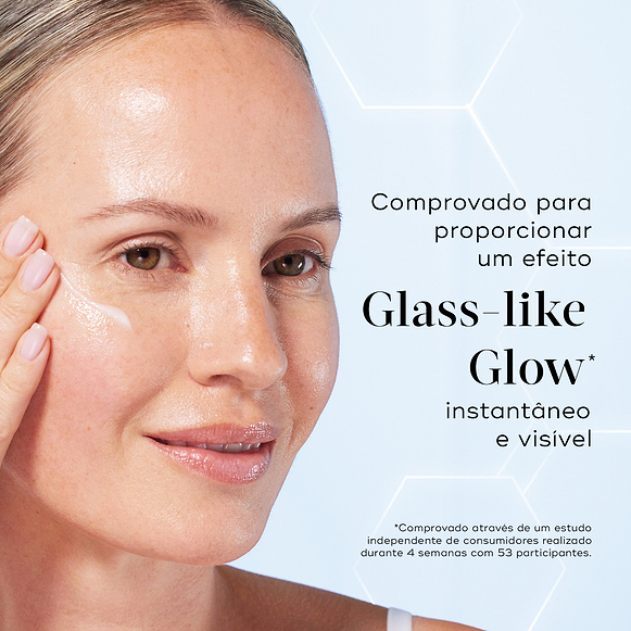 Primeiro plano de uma modella sorridente a aplicar uma porção de sérum branco na bochecha contra um fundo azul claro com gráficos hexagonais subtis. O texto em português destaca que o produto é comprovado para proporcionar um efeito Glass-like Glow instantâneo e visível.-hover-5