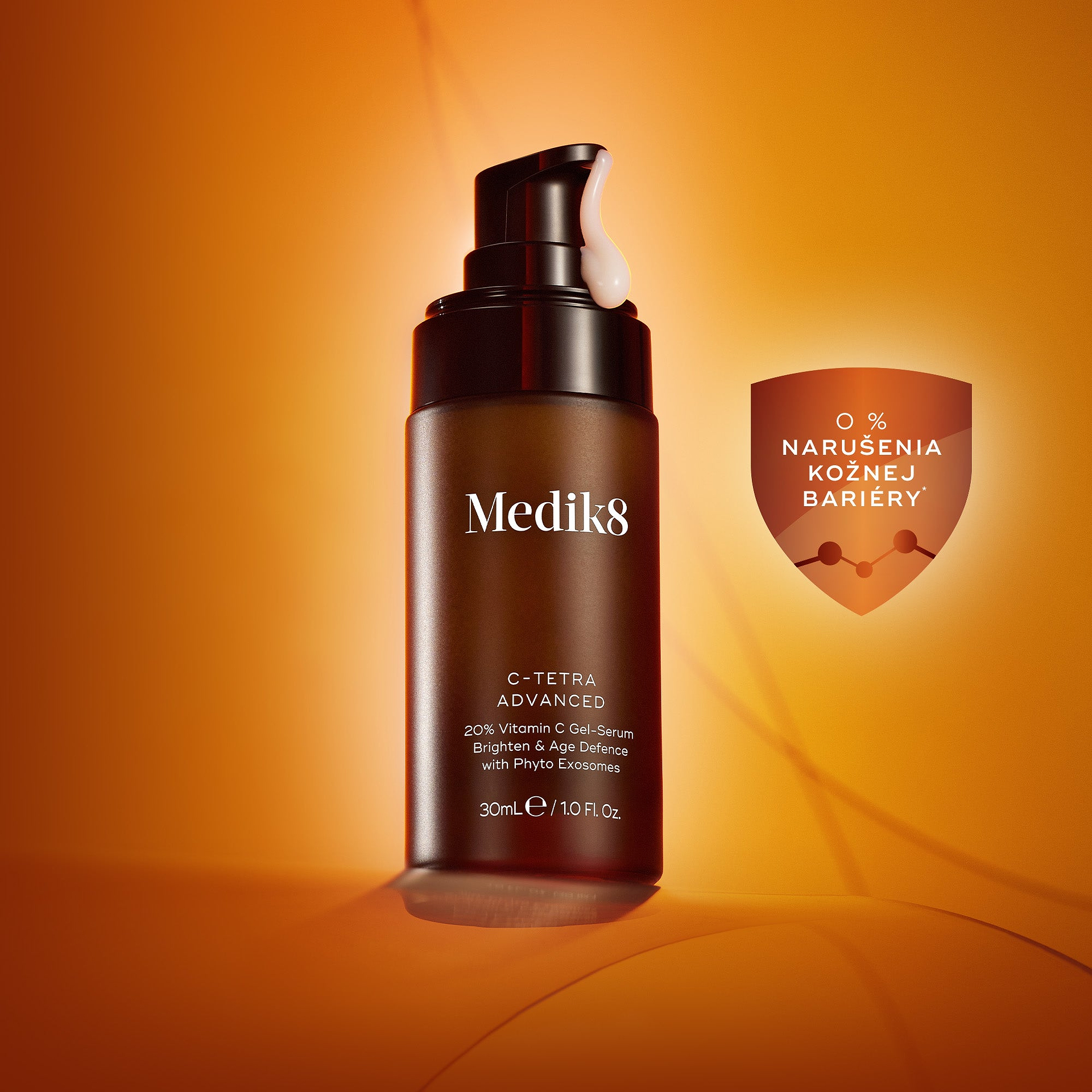Tmavá fľaštička gélového séra Medik8 C-Tetra Advanced 20% Vitamin C s čiernym dávkovačom dávkujúcim gél na teplom oranžovom pozadí, so symbolom štítu a textom „0 % NARUŠENIA KOŽNEJ BARIÉRY“.*