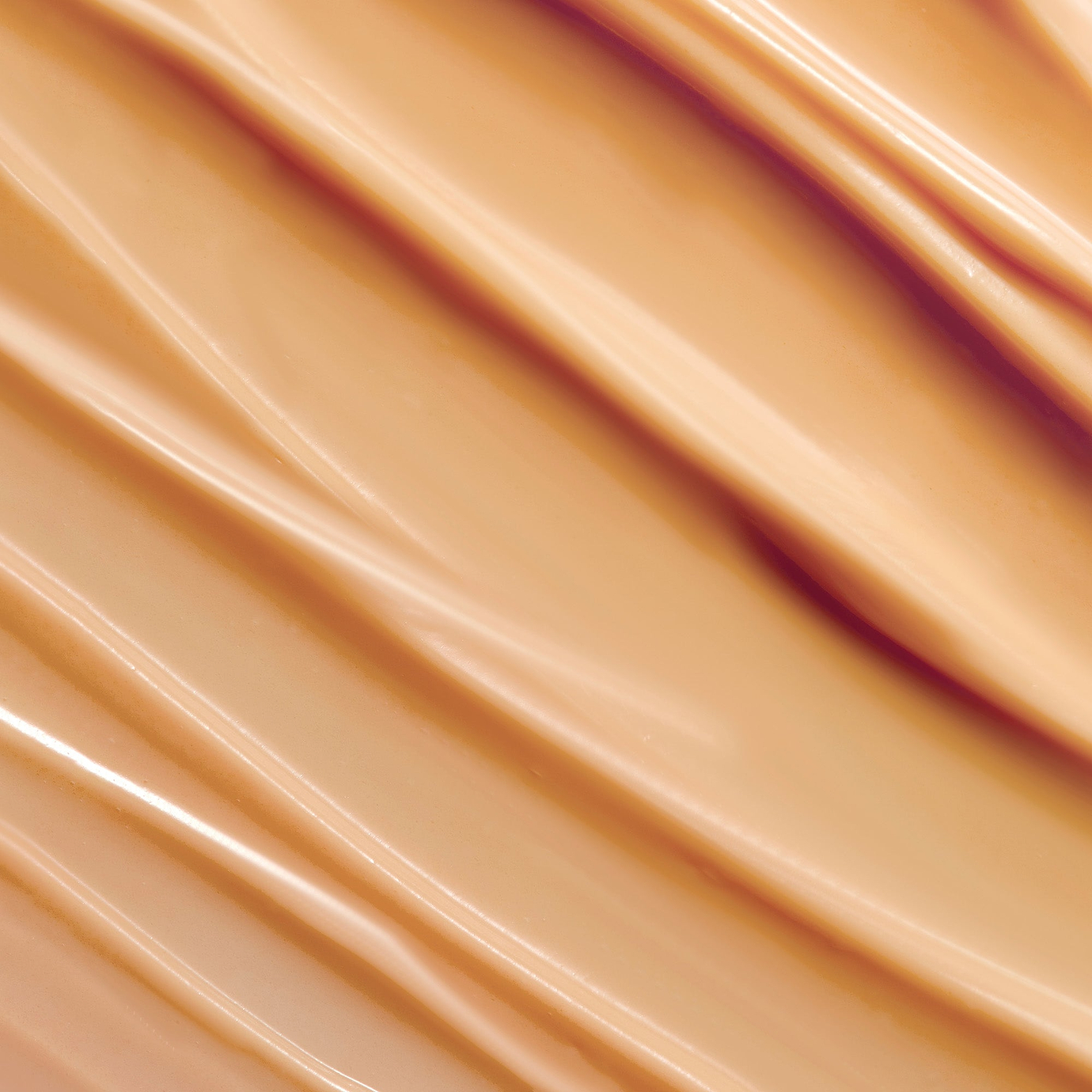 A close-up texture shot of a smooth, peach-coloured cream with soft ripples, representing the Retinaldehyde ingredient.