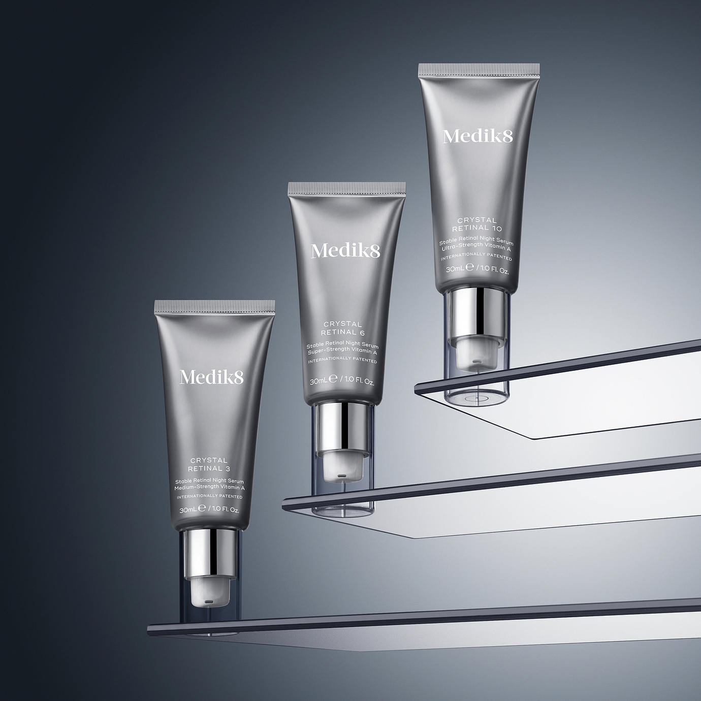 Three silver pump tubes of Medik8 Crystal Retinal displayed ascending on clear, floating glass shelves against a dark grey gradient background. From bottom to top, the tubes are labeled Crystal Retinal 3, Crystal Retinal 6, and Crystal Retinal 10.