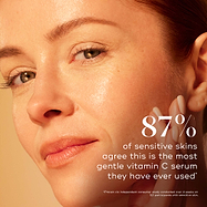 Close-up of a model with glowing skin gently touching her cheek against a warm gradient background. Text highlights that 87% of sensitive skins agree this is the most gentle vitamin C serum they have ever used, proven via an independent consumer study.