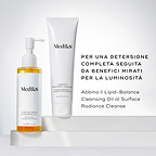 Il flacone di Lipid-Balance Cleansing Oil è posizionato accanto a un tubo di Surface Radiance Cleanse. Il testo consiglia di abbinarli per una detersione completa seguita da benefici mirati per aumentare la luminosità.