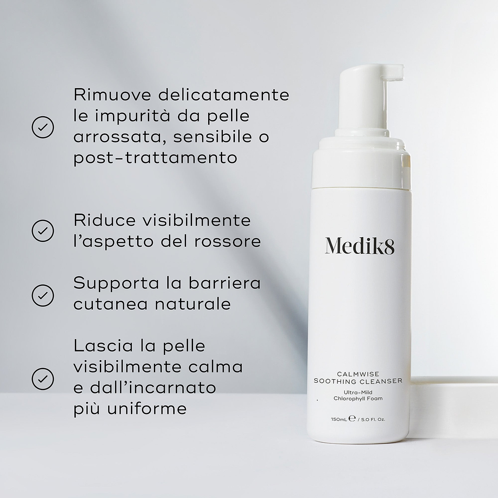 Il flacone di Medik8 Calmwise Soothing Cleanser si trova su un blocco bianco contro uno sfondo grigio chiaro. Il testo in italiano descrive i benefici della schiuma ultra-delicata alla clorofilla, tra cui la rimozione delicata delle impurità dalla pelle arrossata, sensibile o post-trattamento, la riduzione visibile dell'aspetto del rossore, il supporto alla barriera cutanea naturale e il lasciare la pelle visibilmente calma con un incarnato più uniforme.