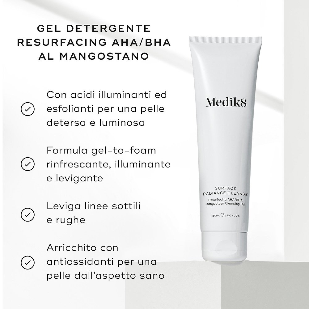 Il tubo di Medik8 Surface Radiance Cleanse poggia su una superficie grigio chiaro testurizzata. Il testo in italiano descrive i benefici del gel detergente resurfacing AHA/BHA al mangostano, includendo acidi illuminanti, una formula gel-to-foam rinfrescante, la levigatura delle linee sottili e l'arricchimento con antiossidanti.