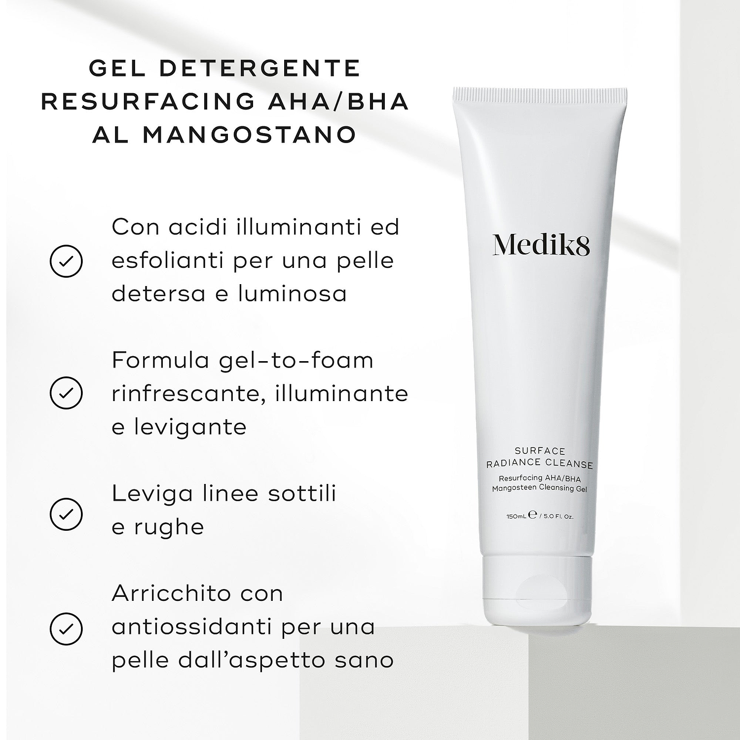 Il tubo di Medik8 Surface Radiance Cleanse poggia su una superficie grigio chiaro testurizzata. Il testo in italiano descrive i benefici del gel detergente resurfacing AHA/BHA al mangostano, includendo acidi illuminanti, una formula gel-to-foam rinfrescante, la levigatura delle linee sottili e l'arricchimento con antiossidanti.