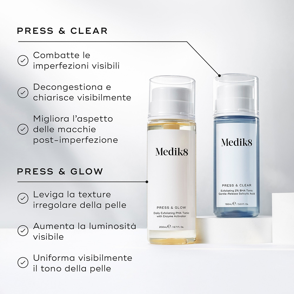 Immagine di confronto che mostra i flaconi Medik8 Press & Glow e Press & Clear affiancati su blocchi espositivi bianchi. Il testo in italiano confronta i loro benefici, notando che Press & Clear combatte le imperfezioni visibili, decongestiona e migliora l'aspetto delle macchie post-imperfezione, mentre Press & Glow leviga la texture irregolare, aumenta la luminosità e uniforma il tono della pelle.