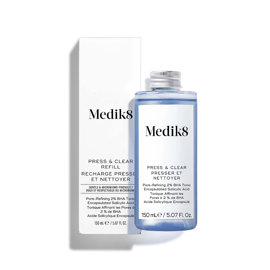 De Medik8 Press & Clear-flacon met blauwe vloeistof staat naast de witte productverpakking. De tekst vermeldt dat het gaat om een "Exfoliating 2% BHA Tonic" met "Gentle-Release Salicylic Acid".