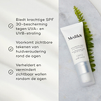 De tube Medik8 Advanced Day Eye Protect ligt op een marmeren oppervlak naast een groene varenblad. De tekst benadrukt de SPF 30-bescherming, het helpen voorkomen van zichtbare tekenen van huidveroudering en het vermogen om de oogcontour te verhelderen en wallen te verminderen.