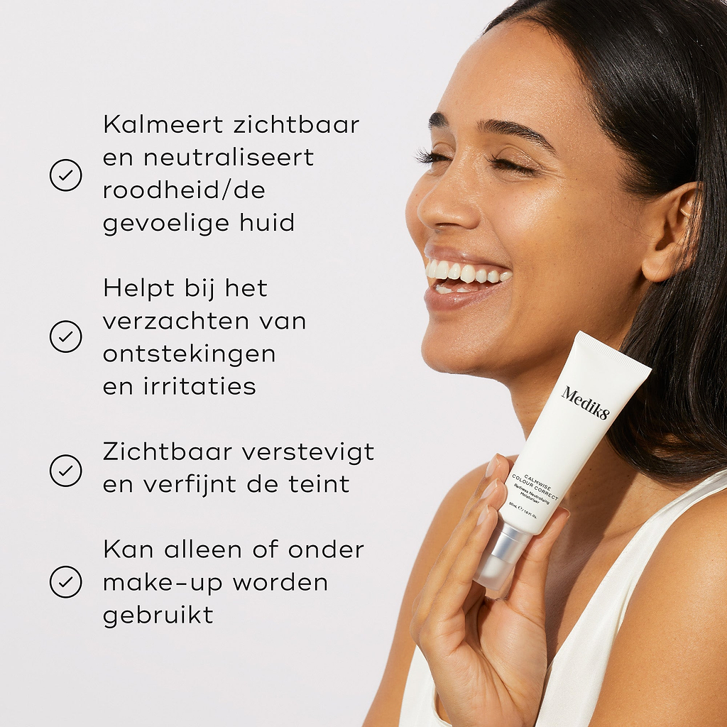 Een vrouw houdt een tube Calmwise Colour Correct vast. Vier opsommingstekens met vinkjes vermelden de voordelen: kalmeert en neutraliseert de roodgevoelige huid zichtbaar, helpt ontstekingen en irritaties te verzachten, maakt de teint zichtbaar gladder en steviger, en kan zowel alleen als onder make-up worden gebruikt.