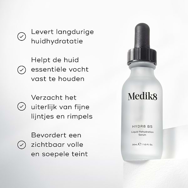 De fles Medik8 Hydr8 B5 serum staat op een witte sokkel tegen een heldere witte achtergrond. De tekst benadrukt dat het product langdurige hydratatie van de huid biedt, helpt om essentieel vocht vast te houden, de zichtbaarheid van fijne lijntjes en rimpels verzacht en zorgt voor een zichtbaar vollere en soepelere huid.
