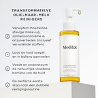 De fles Medik8 Lipid-Balance Cleansing Oil staat op een witte blok. De tekst vermeldt de voordelen, waaronder het verwijderen van zware make-up, het ondersteunen van de lipidenbarrière en het functioneren als een transformerende olie-naar-melk reiniger.
