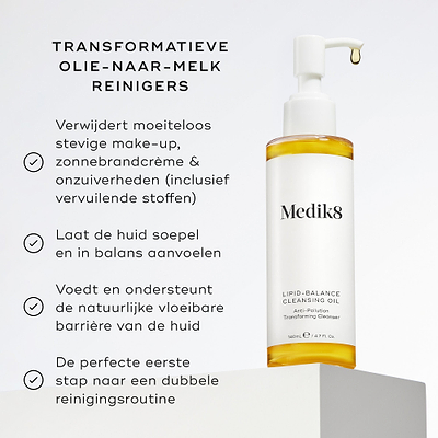 De fles Medik8 Lipid-Balance Cleansing Oil staat op een witte blok. De tekst vermeldt de voordelen, waaronder het verwijderen van zware make-up, het ondersteunen van de lipidenbarrière en het functioneren als een transformerende olie-naar-melk reiniger.
