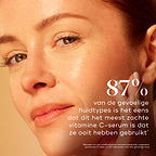 Close-up van een vrouw met een stralende, gezonde teint die haar hand op haar wang laat rusten. De tekst vermeldt: "87% van de mensen met een gevoelige huid is het erover eens dat dit het meest milde vitamine C-serum is dat ze ooit hebben gebruikt." Kleinere tekst onderaan merkt op dat de resultaten gebaseerd zijn over een consumentenonderzoek.