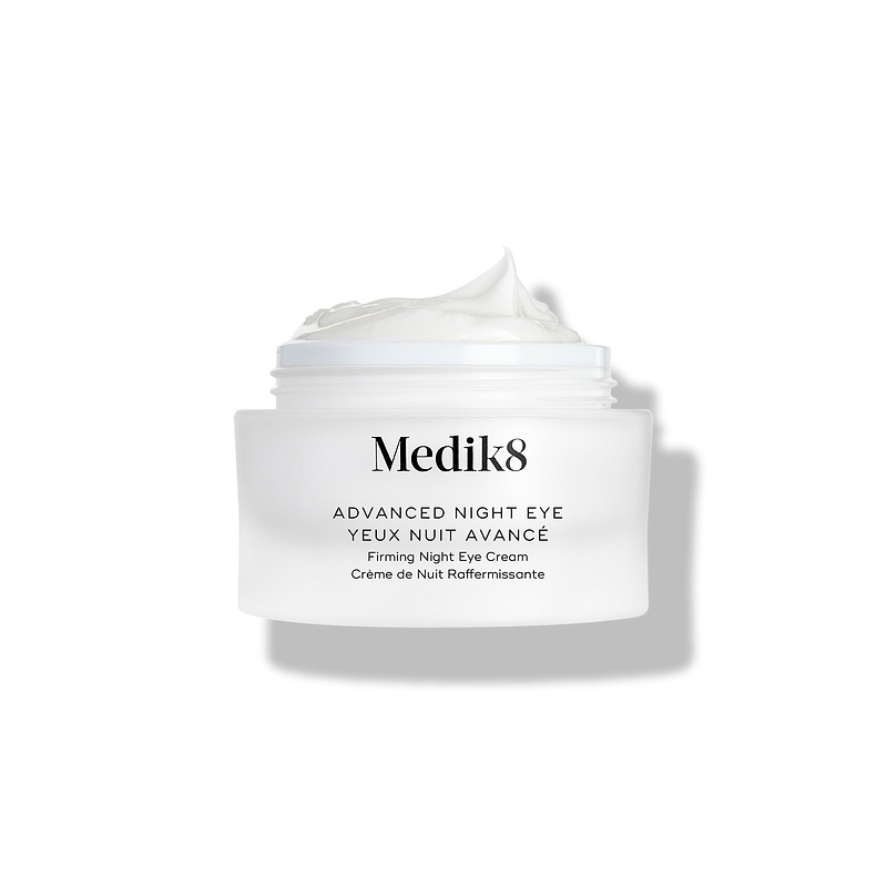 De Medik8 Advanced Night Eye-crèmepot staat tegen een witte achtergrond met de deksel verwijderd. De rijke witte crème is zichtbaar in de pot en benadrukt de textuur.