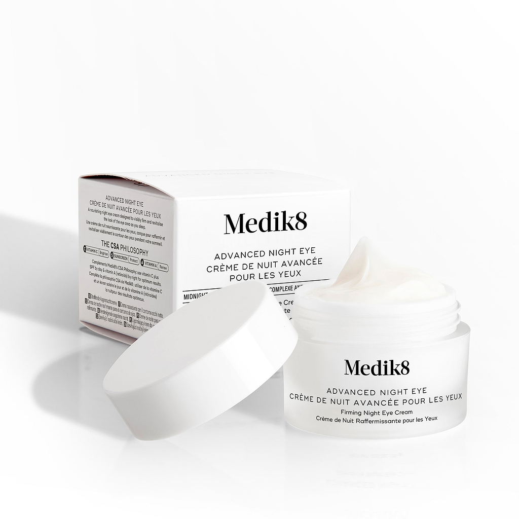 De Medik8 Advanced Night Eye-crèmepot staat geopend naast de productverpakking op een witte achtergrond. 