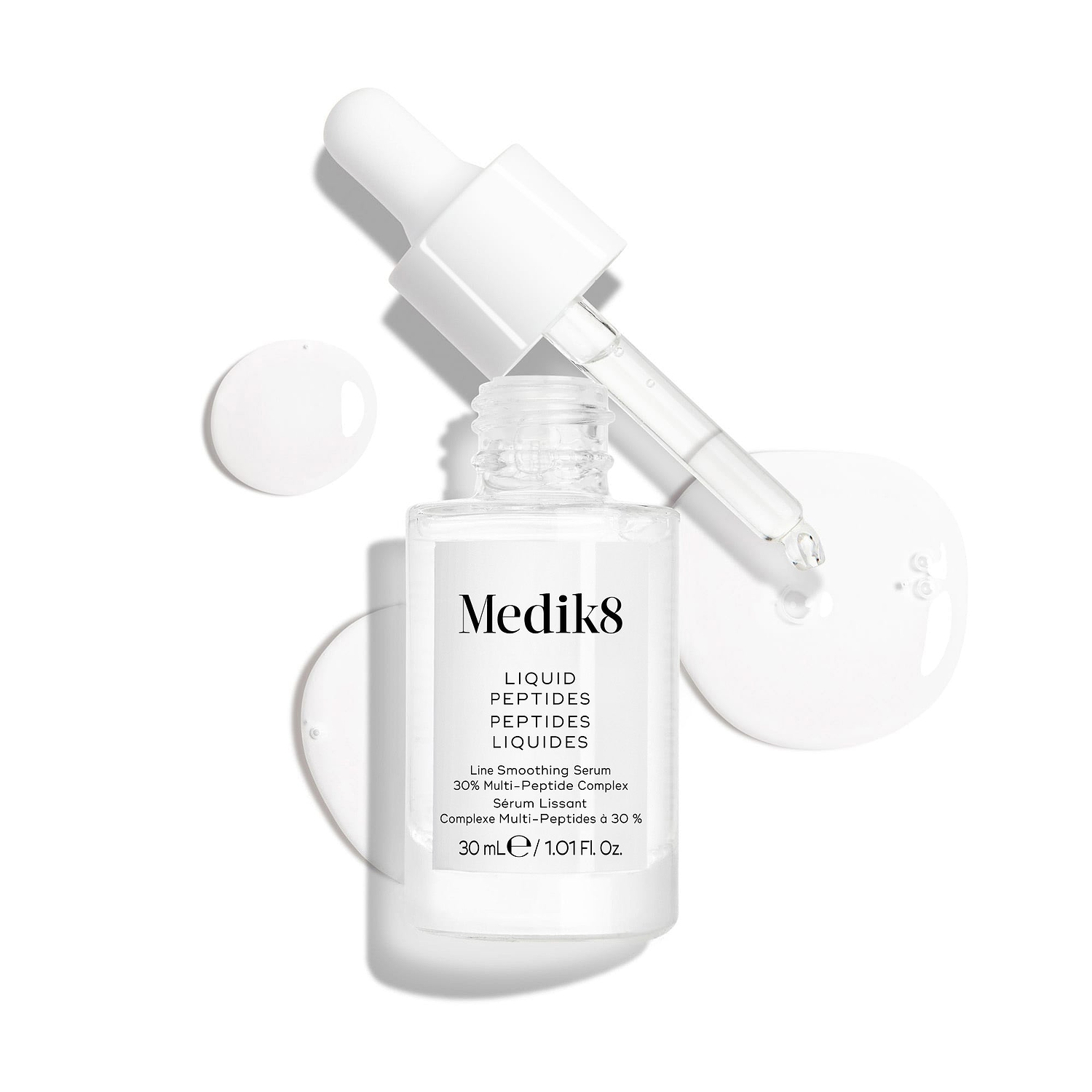 Een heldere glazen pipetflacon van Liquid Peptides-serum wordt weergegeven met de pipet verwijderd en ernaast geplaatst, samen met serumdruppels die de textuur van het serum laten zien.