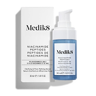 De Medik8 Niacinamide Peptides clarifying serumflacon met witte pomp staat rechtop naast de witte productverpakking tegen een strakke witte achtergrond.