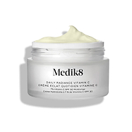 De glazen pot Medik8 Daily Radiance Vitamin C wordt geopend weergegeven met een royale toef lichtgele crème bovenop. De tekst vermeldt dat het product een 50 ml C-Tetra Cream SPF 30 Two-in-One Moisturiser is.
