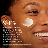 Zbliżenie na profil uśmiechniętej modelki z plamką kremu na policzku. Pogrubiony tekst informuje, że 94% osób uznało, iż preparat Daily Radiance Vitamin C bardziej przypomina krem nawilżający niż filtr przeciwsłoneczny.