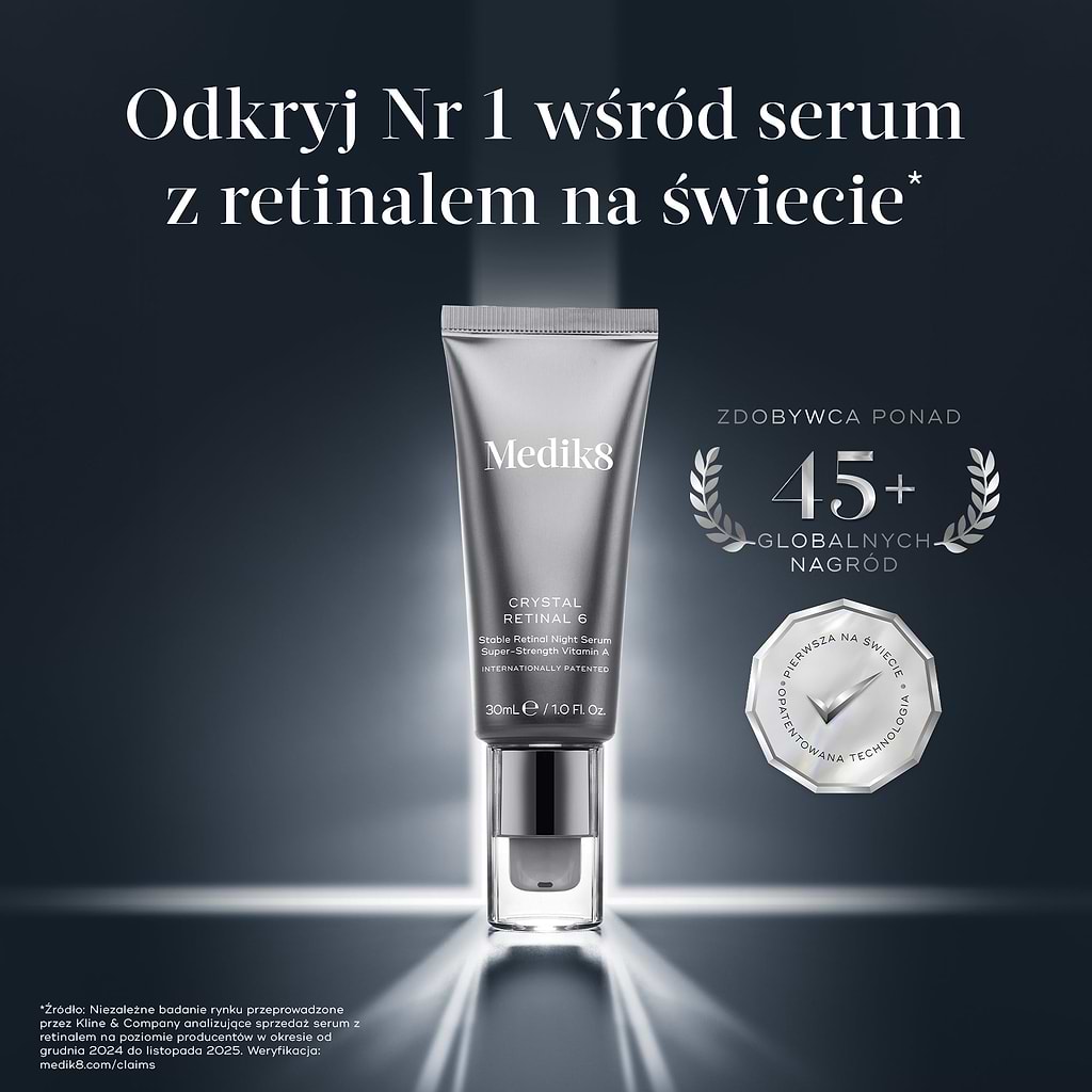 Metaliczna, srebrna tubka serum Medik8 Crystal Retinal 6 ustawiona ukośnie w jasnym świetle reflektora na ciemnoszarym tle z delikatnym wzorem geometrycznych sześciokątów. Obok pompy tubki znajduje się gruba, zakrzywiona próbka kremu w kolorze brzoskwiniowym. W prawym górnym rogu widnieje srebrny, metaliczny emblemat w kształcie wieńca laurowego z napisem „LAUREAT PONAD 45 MIĘDZYNARODOWYCH NAGRÓD”.