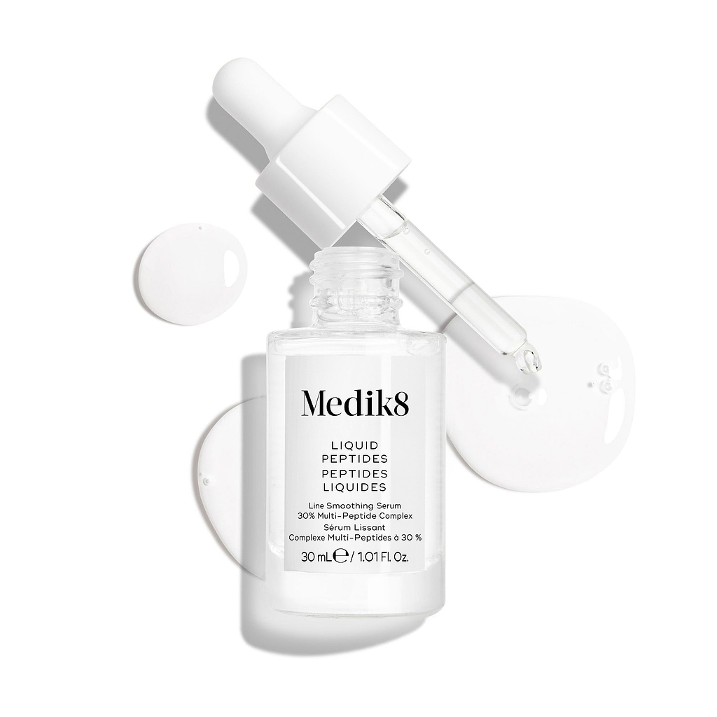 Przedstawiono przezroczystą szklaną buteleczkę z serum Liquid Peptides z zakraplaczem, który został wyjęty i leży obok niej, a także krople serum, które pokazują konsystencję produktu