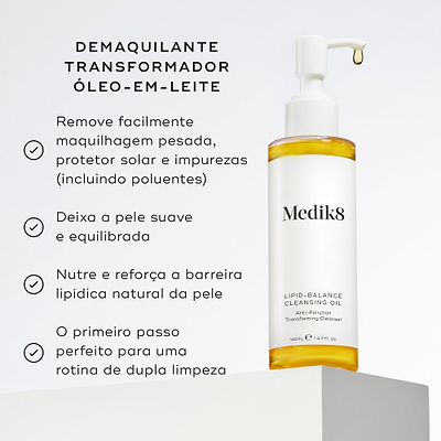 Um frasco doseador de Lipid Balance Cleansing Oil com uma gota caindo do bocal assenta num pedestal branco. Intitulado "DEMAQUILANTE TRANSFORMADOR ÓLEO-EM-LEITE", os marcadores listam os benefícios: remove facilmente maquilhagem pesada, protetor solar e impurezas (incluindo poluentes); deixa a pele suave e equilibrada; nutre e reforça a barreira lipídica natural da pele; e é o primeiro passo perfeito para uma rotina de dupla limpeza.