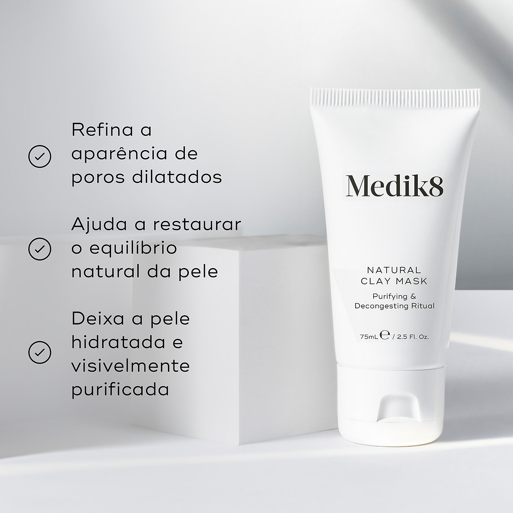 O tubo Natural Clay Mask está ao lado de um pedestal cúbico branco contra um fundo claro. Os marcadores listam os seus benefícios: refina a aparência de poros dilatados, ajuda a restaurar o equilíbrio natural da pele, e deixa a pele hidratada e visivelmente purificada.