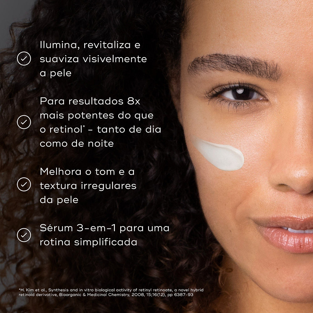 Close-up de uma mulher sorridente com um pouco de creme na bochecha contra um fundo escuro. Os marcadores listam os benefícios: ilumina, revitaliza e suaviza visivelmente a pele; proporciona resultados 8x mais potentes do que o retinol (de dia e de noite); melhora o tom e a textura irregulares da pele; e atua como um sérum 3-em-1 para uma rotina simplificada.