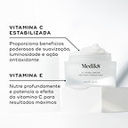 Um pote aberto de Medik8 C-Tetra Cream revelando o creme branco no interior, colocado sobre um bloco branco contra um fundo claro. O texto em português destaca os ingredientes principais: Vitamina C Estabilizada que proporciona benefícios poderosos de suavização, luminosidade e ação antioxidante, e Vitamina E que nutre profundamente e potencia o efeito da vitamina C para resultados máximos.