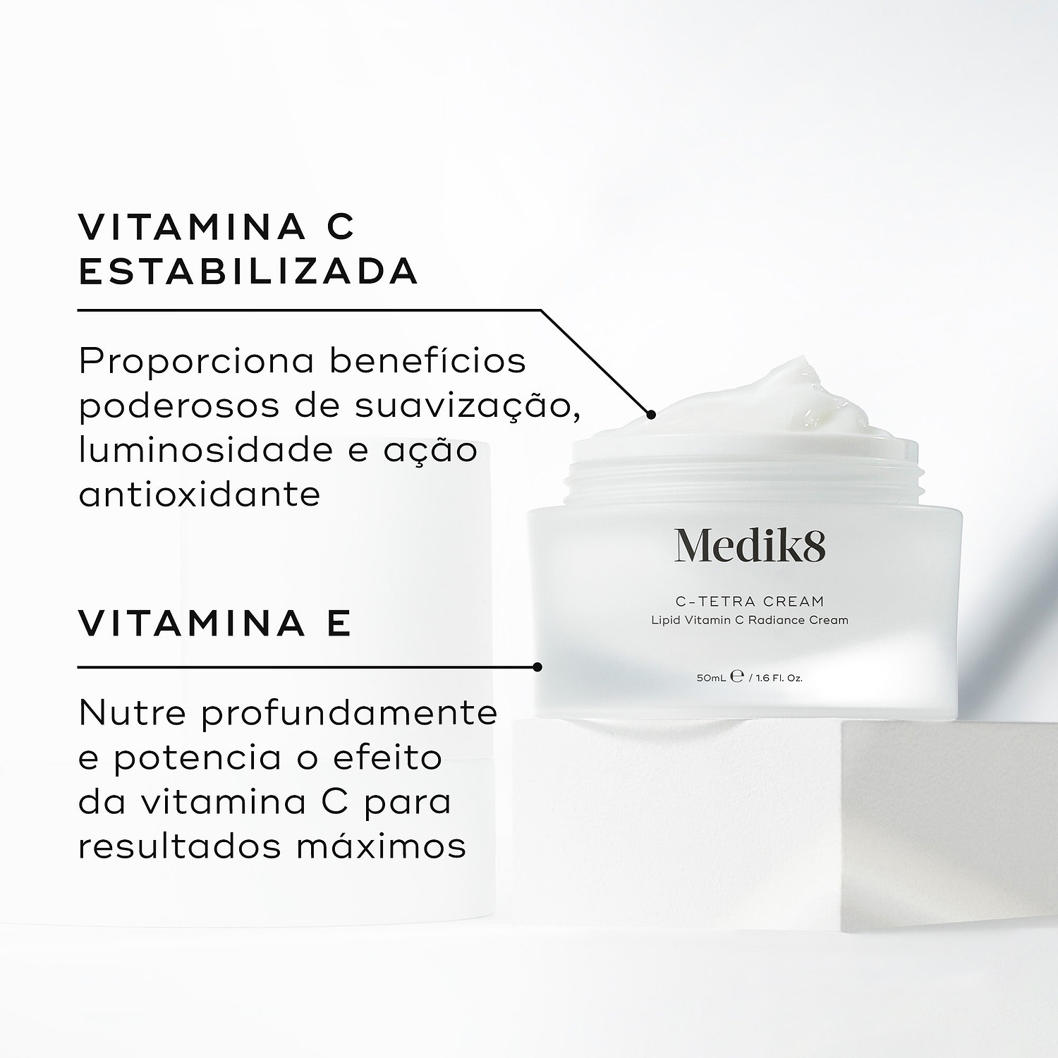 Um pote aberto de Medik8 C-Tetra Cream revelando o creme branco no interior, colocado sobre um bloco branco contra um fundo claro. O texto em português destaca os ingredientes principais: Vitamina C Estabilizada que proporciona benefícios poderosos de suavização, luminosidade e ação antioxidante, e Vitamina E que nutre profundamente e potencia o efeito da vitamina C para resultados máximos.