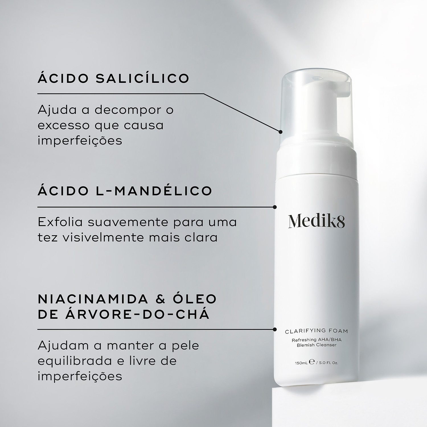 O frasco doseador Clarifying Foam assenta num pedestal branco contra um fundo cinza claro. Linhas de texto destacam os ingredientes-chave: Ácido Salicílico para ajudar a decompor o excesso de óleo que causa imperfeições, Ácido L-Mandélico para esfoliar suavemente para uma tez visivelmente mais clara, e Niacinamida e Óleo de Árvore-do-Chá para ajudar a manter a pele equilibrada e livre de imperfeições.